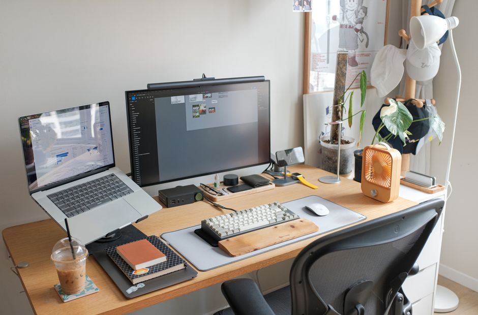 Una configuración de oficina elegante con laptop, monitor y accesorios que mejoran la productividad.