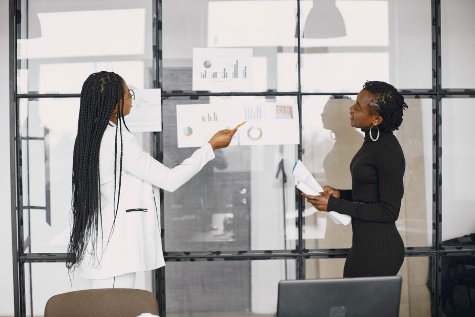 Dos empresarias discutiendo gráficos financieros